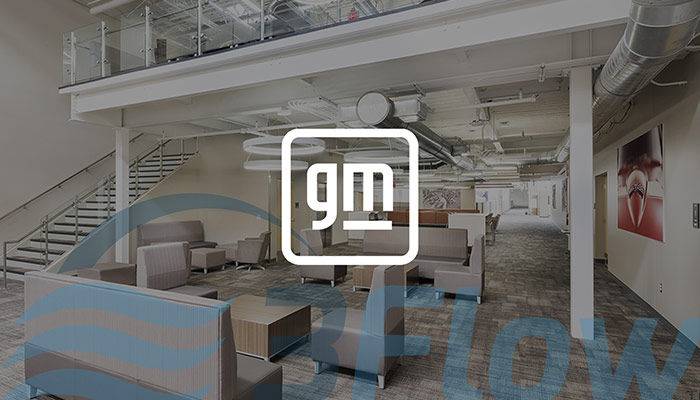 GM logo over darkened photo of their building lobby